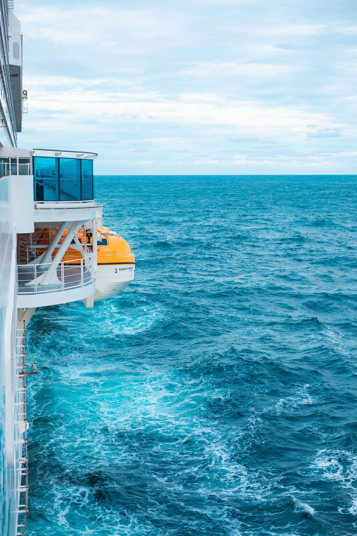 The turquoise wake alongside a cruise ship